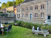 a yard with a chair and a stone building at Charmante petite maison à Olne in Olne