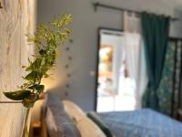 a plant in a vase next to a bed at Cocooning Tropic Studio avec Jacuzzi privatif in Saint-Louis