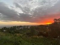 a view of a sunset from a hill with trees at Cocooning Tropic Studio avec Jacuzzi privatif in Saint-Louis