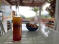 a bottle of drink on a table with a bowl of fruit at Cocooning Tropic Studio avec Jacuzzi privatif in Saint-Louis