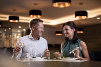 a man and a woman sitting at a table with wine glasses at Nuhr Medical - Hotel & Restaurant - Ab 2 Nächte von 13 Feb 26 - 15 Feb 26 Kostenlose Zimmerdekoration & 1 Flasche Sekt für den Valentinstag, Champagner & Kaviar am 14 Feb um 18 Uhr bitte Tisch vorreservieren in Senftenberg