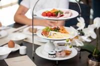 a person holding two plates of food on a table at Nuhr Medical - Hotel & Restaurant - Ab 2 Nächte von 13 Feb 26 - 15 Feb 26 Kostenlose Zimmerdekoration & 1 Flasche Sekt für den Valentinstag, Champagner & Kaviar am 14 Feb um 18 Uhr bitte Tisch vorreservieren in Senftenberg