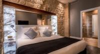 a bedroom with a large bed with a stone wall at Hotel Marais Grands Boulevards in Paris