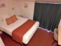 a hotel room with a bed and a window at Hôtel les Platanes in Villeneuve-sur-Lot