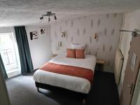 a bedroom with a bed and a window at Hôtel les Platanes in Villeneuve-sur-Lot