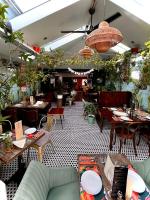 索尔科姆Brightham House - Exclusively for Adults的有桌椅和植物的餐厅