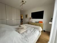 a bedroom with a white bed and a flat screen tv at Appartement Luxueux 3 pièces climatisé avec Terrasse, 5 couchages - 17ème Arrondissement de Paris in Clichy
