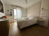 a bedroom with a white bed and a window at Appartement Luxueux 3 pièces climatisé avec Terrasse, 5 couchages - 17ème Arrondissement de Paris in Clichy