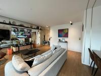 a living room with a couch and a tv at Appartement Luxueux 3 pièces climatisé avec Terrasse, 5 couchages - 17ème Arrondissement de Paris in Clichy