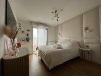 a white bedroom with a bed and a table at Appartement Luxueux 3 pièces climatisé avec Terrasse, 5 couchages - 17ème Arrondissement de Paris in Clichy