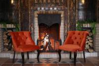 Dos sillas naranjas frente a una chimenea en Armaco Residence, en Koprivshtitsa