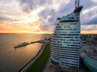 a tall building next to a body of water at Atlantic Hotel Sail City in Bremerhaven