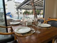 a wooden table with plates and wine glasses on it at Colaklı Sunset Otel in Side