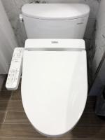 a white toilet in a bathroom with a remote control at Dynasty Hotel in Tainan