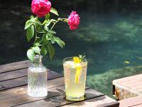 a vase with a flower and a drink on a table at Blu Monkey Pooltara Krabi Hotel & Villas Pet Friendly in Tha Lane Bay