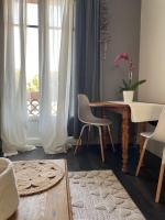 a living room with a table and chairs and a window at Spacieux T3 haussmannien in Toulon