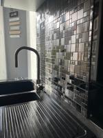 a kitchen with a sink and a tile wall at Spacieux T3 haussmannien in Toulon