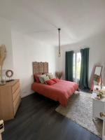 a bedroom with a bed with red sheets and green curtains at Spacieux T3 haussmannien in Toulon
