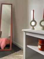 a room with a mirror and a table with a shelf at Spacieux T3 haussmannien in Toulon