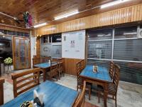 um restaurante com mesas e cadeiras e um quadro branco em Hotel CM Palace - Pure Vegetarian em Ner Chowk