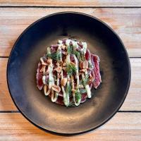 ein Teller mit Essen auf einem Holztisch in der Unterkunft ho36 Les Menuires in Les Menuires
