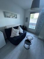 a living room with a blue couch and a table at MINI STUDIO DANS UN COIN DE VERDURE in Montélimar