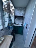 a small kitchen with a sink and a table at MINI STUDIO DANS UN COIN DE VERDURE in Montélimar