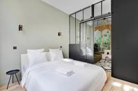 a bedroom with a large white bed and a glass wall at GemBnB Luxury Apartments - Sedaine in Paris