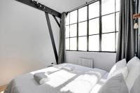 a bedroom with two beds and two windows at GemBnB Luxury Apartments - Sedaine in Paris