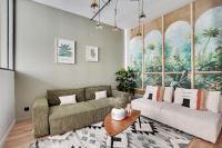 a living room with a couch and a large window at GemBnB Luxury Apartments - Sedaine in Paris