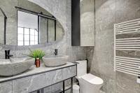 a bathroom with a sink and a toilet and a mirror at GemBnB Luxury Apartments - Sedaine in Paris