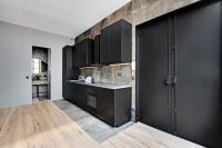 a kitchen with black cabinets and a wooden floor at GemBnB Luxury Apartments - Sedaine in Paris