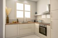 a kitchen with white cabinets and a sink and a window at SeãCret in Kolymvari