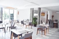 利伯维尔Résidence Flana B的一家有桌椅和窗户的餐厅