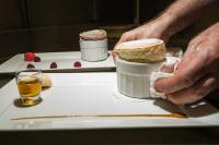 a person holding a piece of cake on a plate at Logis Hôtel Auberge du Cheval Blanc in Yvoy-le-Marron