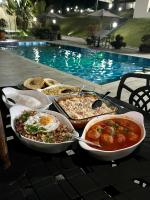 a table topped with dishes of food next to a pool at Pousada Dona Tereza in Guapé
