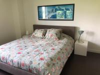 a bedroom with a bed with a floral comforter at landelijke villa met zwembad en gezellige openhaard in Zemst