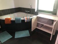 a bathroom with a tub with towels and a mirror at landelijke villa met zwembad en gezellige openhaard in Zemst