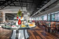 un restaurante con una mesa con platos de comida. en Ohana Phnom Penh Palace Hotel, en Phnom Penh