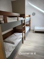 a room with three bunk beds in a dorm room at Storchencamp Gästehaus Purbach in Purbach am Neusiedlersee