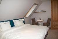 a bedroom with a large white bed with a skylight at B&amp;B - Ter Douve in Dranouter