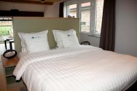 a bedroom with a large bed with white sheets and pillows at B&amp;B - Ter Douve in Dranouter