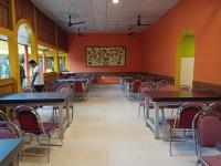 an empty dining room with tables and chairs at Atithya Resort in Khānāpāra