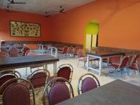 an empty room with tables and chairs in it at Atithya Resort in Khānāpāra