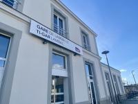 a white building with a sign on the side of it at Bienvenue chez Tom in Lamballe