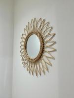 a gold sunburst mirror hanging on a wall at Bienvenue chez Tom in Lamballe