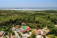an aerial view of a house with trees and a lake at Giourgas house in Chlomatianá