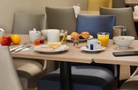 a wooden table with breakfast foods and drinks on it at Jardin de Villiers in Paris