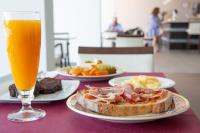 セデイラにあるHotel Herbeiraの食べ物の皿とオレンジジュースのグラスが置かれたテーブル