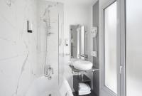 a white bathroom with a sink and a shower at Jardin de Villiers in Paris